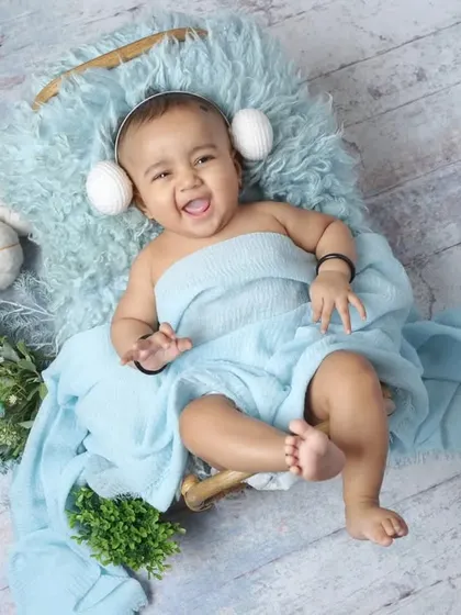A simple and sweet portrait of a happy baby wrapped in blue fabric. The overhead shot in a basket setup shows the versatility of our studio sessions, even for simple concepts.