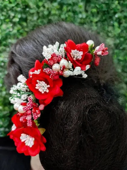 A classic red and white floral hair veni. The combination of red flowers, white buds, and pearls is perfect for a traditional bridal bun.