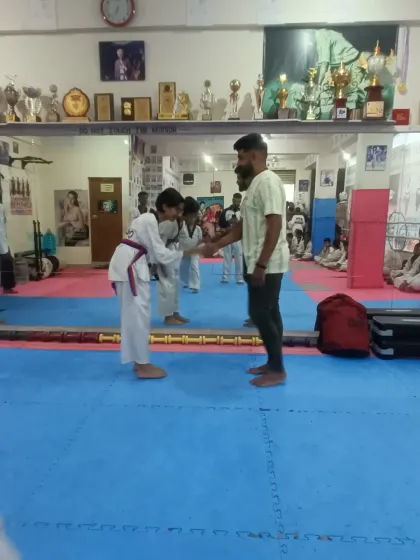 A student receives her red belt.