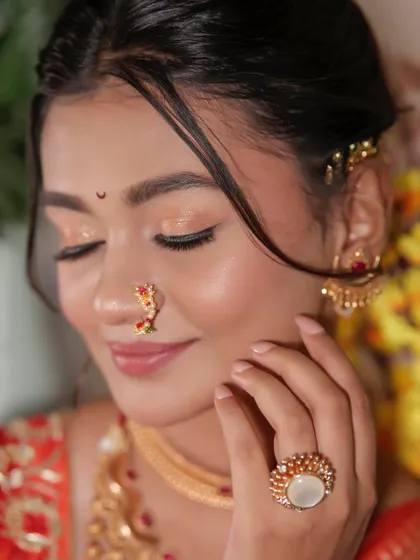 A close-up on the delicate eye makeup and traditional nath.