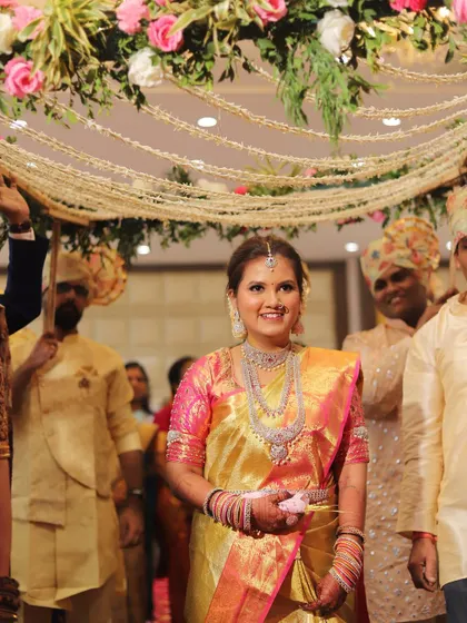 The bride's grand entrance during her South Indian wedding. Her golden Kanchipuram saree and diamond jewelry create a truly royal look.