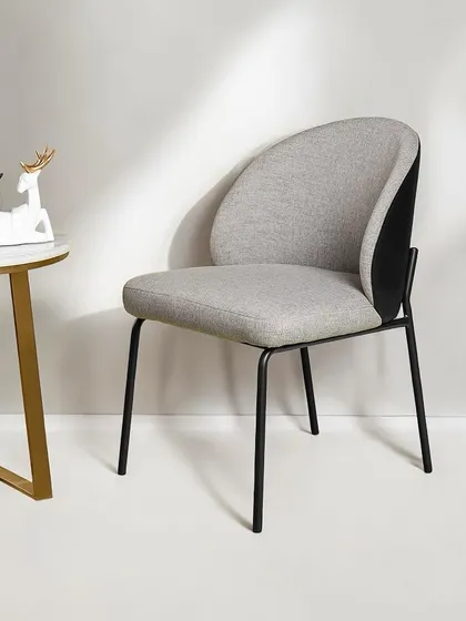 This modern dining or accent chair features a comfortable curved back and a sleek black metal frame. The two-tone grey and black upholstery adds a touch of contemporary sophistication.