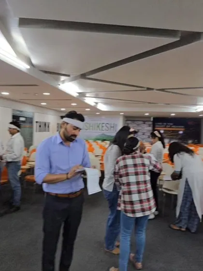 Participants engaged in a blindfolded communication exercise. Activities like these are designed to improve listening skills, build trust, and highlight how clear instructions are vital for team success.