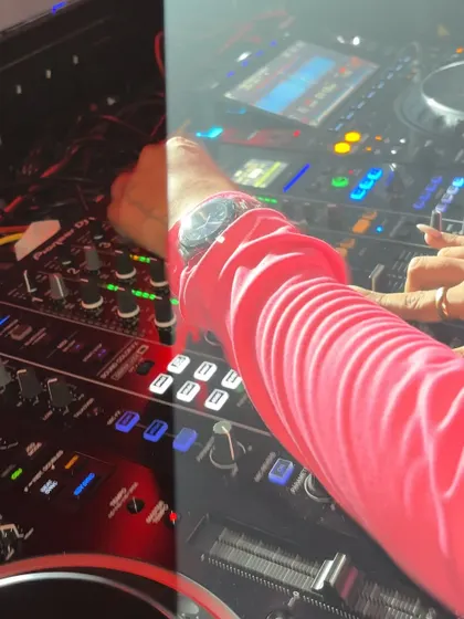 A unique split-screen view showing a close-up of my hand on the colorful, illuminated DJ controller.