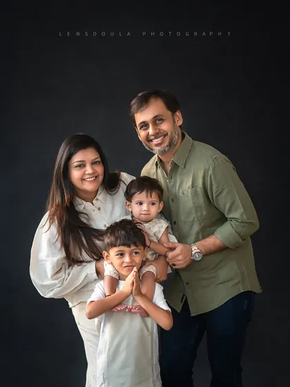 A lovely family of four portrait, with the older brother proudly holding his little sister. These are the moments that truly define a family's love story.