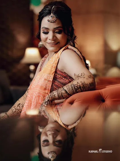 A beautiful reflection shot of the bride during her Mehendi, capturing her serene expression.