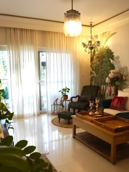A wider view of another cozy corner setup, featuring a classic armchair and ottoman. The jute rug and side table complete this perfect spot for relaxation.