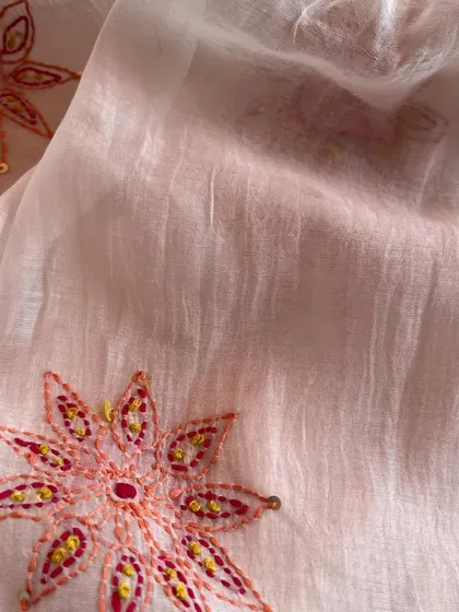 This hand-embroidered Mul Chanderi features delicate floral motifs, showcasing the beauty of traditional craftsmanship on a lightweight fabric.