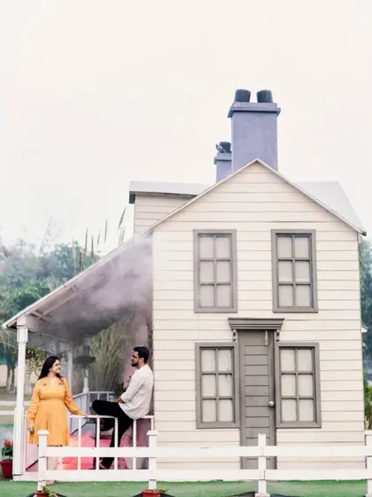 A whimsical pre-wedding shot featuring a dollhouse-like set, adding a touch of fantasy and playfulness to the session.