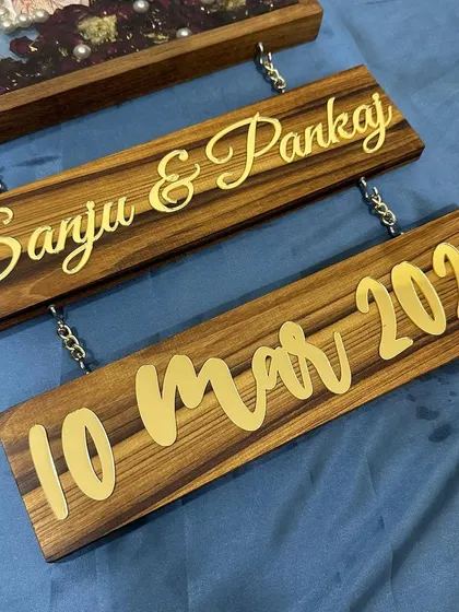 A close-up of the hanging name and date plaques. This design adds a unique, dangly element to the traditional photo frame.