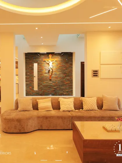 A closer look at a living space designed for comfort and connection. The large, curved sofa provides ample seating, while the feature wall with a crucifix adds a personal and spiritual touch to this modern home.