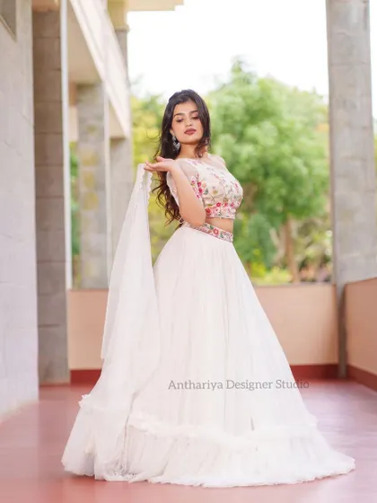 A full-length view from the side, showing the flow of the white georgette skirt and sheer dupatta.