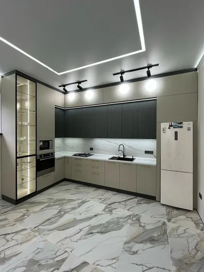 A showcase of our modern kitchen designs, this space combines functionality with sleek aesthetics. We used a dual-tone scheme with matte black and beige cabinets, a marble-patterned backsplash, and integrated profile lighting for a clean, contemporary look.