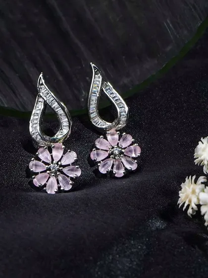 Another angle of these beautiful floral earrings, styled with delicate white flowers. This adds a soft, natural element to the product shot.