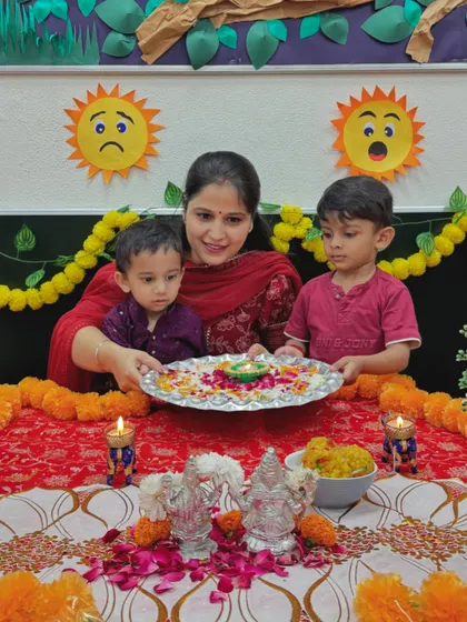 A teacher and two students with a beautifully decorated puja thali for Diwali. We involve children in the preparations to teach them the significance of the festival's rituals.