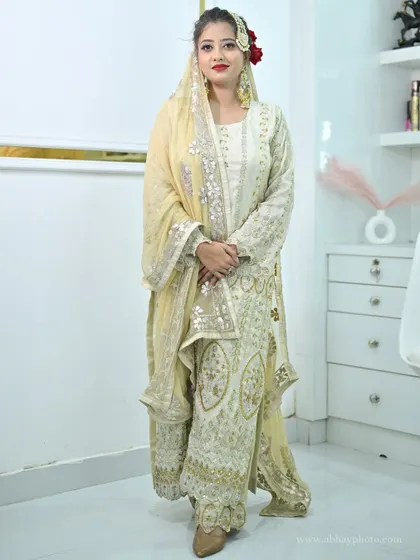 A full-length view of the elegant ivory sharara set, highlighting its intricate embroidery and graceful silhouette.
