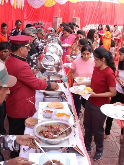 A candid shot of guests enjoying the buffet selection at an outdoor function. We offer a diverse menu to cater to all tastes and preferences.