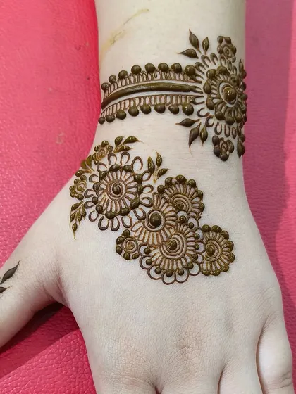 Here you can see the complete minimal design on the hand. It's a great example of how negative space can make the intricate details of the floral patterns and wristlet stand out.