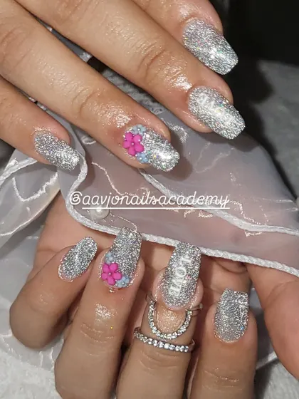 Another view of this sparkling engagement nail set. The high-shine glitter polish catches the light beautifully, while the small, hand-sculpted flowers provide a delicate and feminine detail.