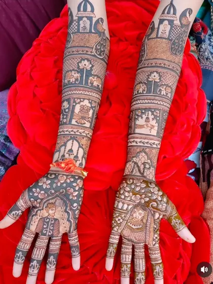 This design features bride and groom portraits on the palms, set against a backdrop of floral and geometric patterns, with elephants and lotus motifs on the arms.