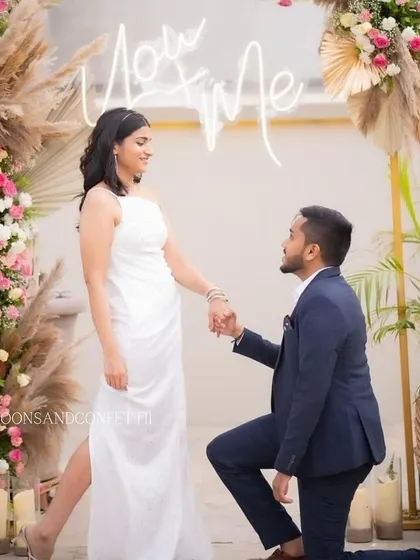 Capturing the moment he got down on one knee. This rooftop proposal combined boho-chic pampas grass arrangements with a modern "You + Me" neon sign, creating a stylish and personal setting.