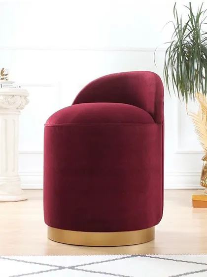 How cute is this ottoman? This piece features a cylindrical form upholstered in rich burgundy velvet, with a polished gold swivel base, adding a touch of glamour and versatility.
