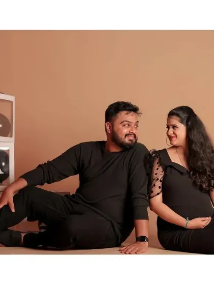 A candid, happy moment between the couple during their black-themed maternity session.