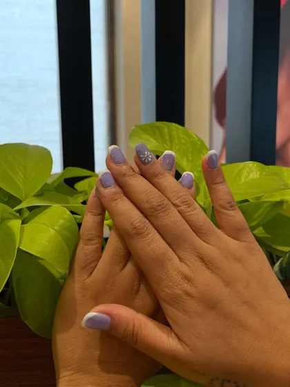 A lovely two-hand pose showing the full lavender and daisy nail art set. It’s a sweet and chic look for any season.
