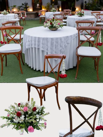 A closer look at our guest seating details. The warmth of the wooden cross-back chairs is complemented by fresh floral centerpieces and delicate jasmine tassels on the chairs.