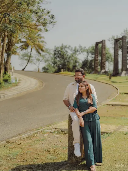 A stylish portrait of the couple posing by a winding country road, showcasing their coordinated outfits and relaxed confidence.