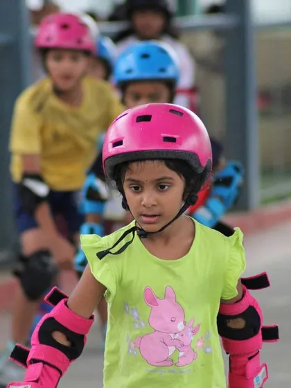 A young skater in full gear, focused on the path ahead. We ensure every child wears a helmet, knee pads, elbow pads, and wrist guards during every session to make safety our top priority.