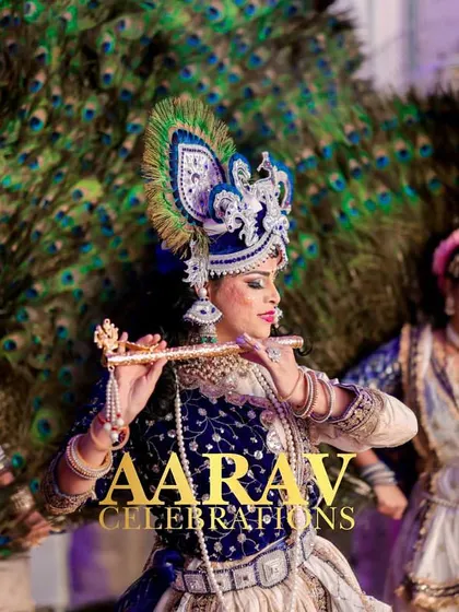 An artist portraying Krishna plays the flute, surrounded by Gopis against a backdrop of peacock feathers. This level of thematic detail creates a truly divine and memorable performance.