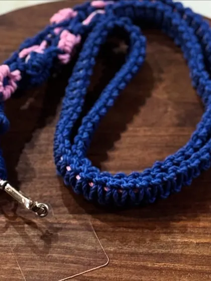 A stylish and strong macrame lanyard for your mobile phone. This one is in navy blue with pink flower details. It's 25 inches long and very durable.