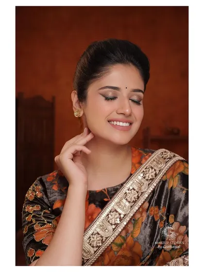 A smiling portrait of the model. The makeup is timeless and sophisticated, with a focus on the eyes, showing that a classic look can also be warm and joyful.