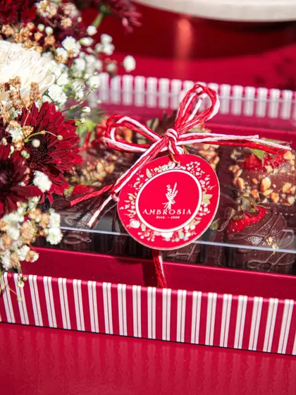 A beautifully tied ribbon and our custom tag adorn a box of Valentine's Day treats, promising something delicious inside.