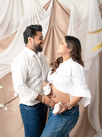 A sweet and casual maternity photo where the couple holds tiny baby shoes up to the baby bump. This simple, heartfelt pose is perfect for capturing the excitement of expecting.