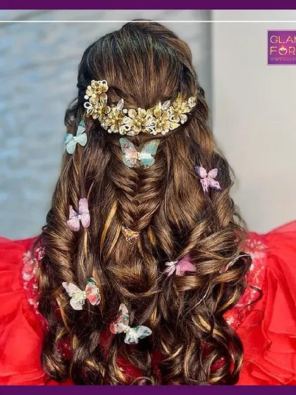 A whimsical and romantic hairstyle with soft waves and butterfly accessories. This is a dreamy look for a daytime event or a pre-wedding photoshoot.