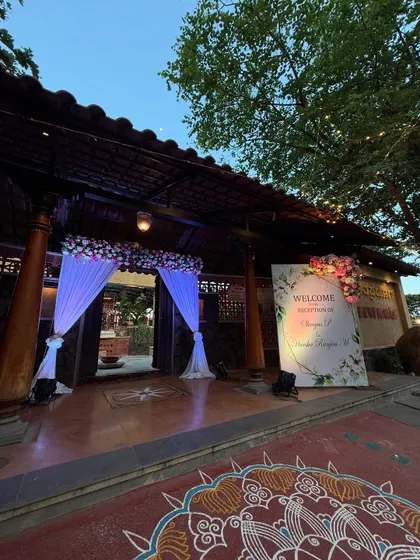 The entrance to an evening engagement party, with a beautiful welcome sign and floral decor that glows under the lights.