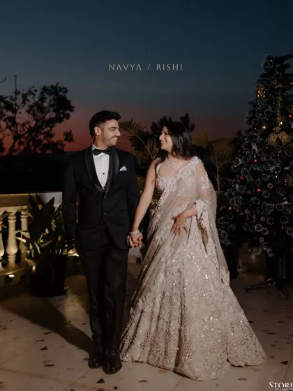 A romantic portrait of the engaged couple against a twilight sky, with a Christmas tree adding a festive touch to the scene.