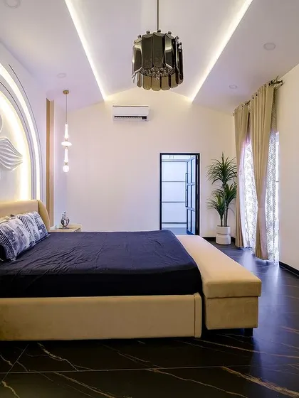 Another angle of the bedroom with the arched floral headboard, showcasing the spacious layout, contemporary lighting, and the seamless integration of the bed with an extended bench.
