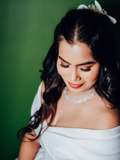 A high-angle shot showcasing the half-up hairstyle and the warm, bronzy eye makeup. A truly glamorous and modern bridal style.