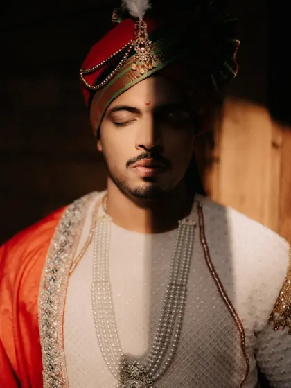 A striking portrait of the groom, with a dramatic shadow falling across his face, highlighting his regal turban.