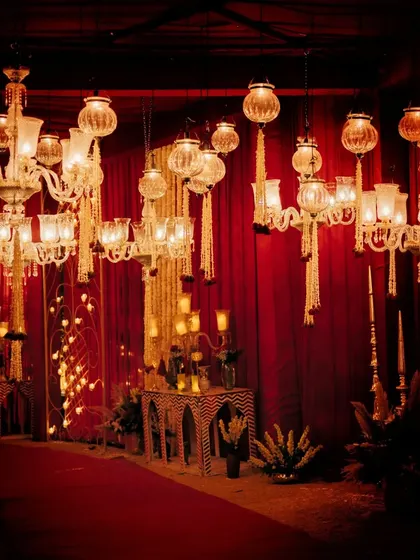 The opulent decor of the Royal Marwar wedding, with a dramatic red carpet entrance flanked by magnificent chandeliers.