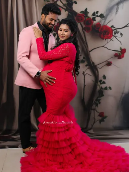 A lovely couple's portrait with a floral backdrop, the pink gown and matching blazer creating a coordinated and stylish look.