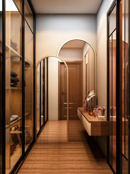 A well-designed walk-in closet brings order and luxury to your daily routine. This custom corridor-style closet features glass-paneled doors, warm interior lighting, and a dedicated vanity nook, blending visibility with sophisticated organization.