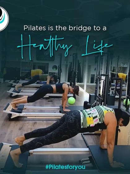 A full class engaged in a plank variation on the Reformers. The shared effort and energy in the room create a powerful and motivating environment for everyone to push their limits.