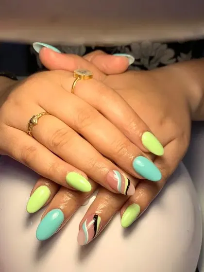 A fun pastel set with a mix of light green and blue nails and abstract, colorful accent nails.