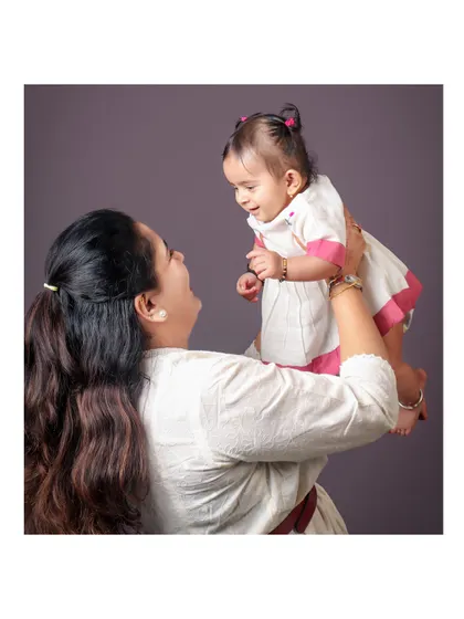 A mother lifts her baby into the air, sharing a moment of pure delight. I love capturing the playful and dynamic interactions within a family.
