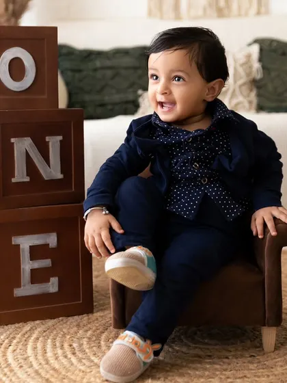 A happy, relaxed portrait of the birthday boy in his smart blue suit, smiling brightly for the camera.