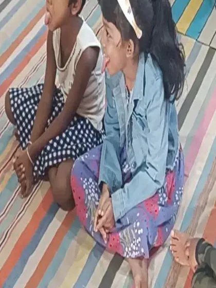Two children playfully stick out their tongues, mimicking the chameleon in the story. This is a perfect example of learning through imitation and fun.